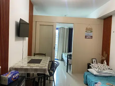 a room with a bed and a table in a room at Moa Staycaion Stern Homes in Manila