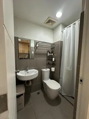 a bathroom with a toilet and a sink and a shower at Prime Salcedo Square Studio 2 Beds in Manila