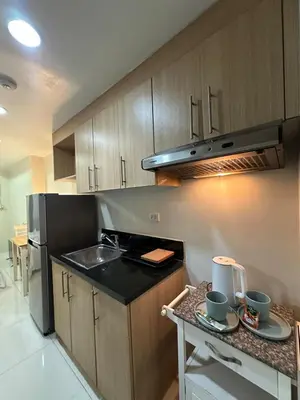 a kitchen with a sink and a stove top oven at Prime Salcedo Square Studio 2 Beds in Manila