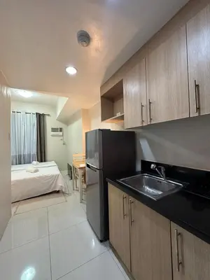 a kitchen with a sink and a bed in a room at Prime Salcedo Square Studio 2 Beds in Manila