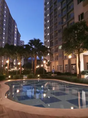 a large swimming pool in a city at night at Haute Haven - 1br with Balcony in Manila