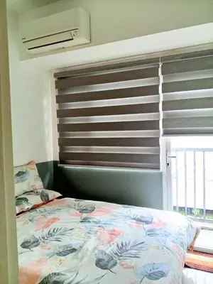a bedroom with a bed and a window with a shutter at Haute Haven - 1br with Balcony in Manila