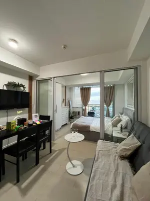 a bedroom with a bed and a desk and a couch at Cozy Corner By R&K in Manila