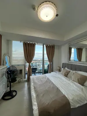 a bedroom with a large bed and a large window at Cozy Corner By R&K in Manila