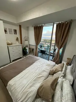 a bedroom with a large bed and a balcony at Cozy Corner By R&K in Manila