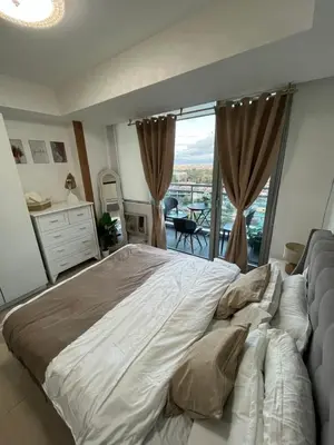 a large bed in a bedroom with a large window at Cozy Corner By R&K in Manila