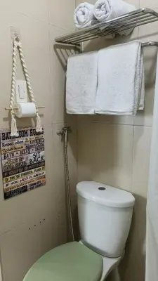 a small bathroom with a white toilet and towels at 2 Bedroom MEZZA RESIDENCES in Manila