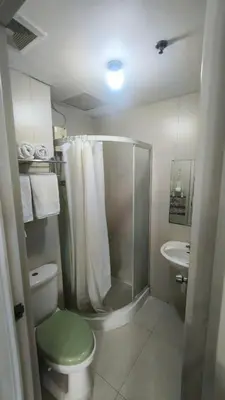 a bathroom with a shower and a toilet and a sink at 2 Bedroom MEZZA RESIDENCES in Manila