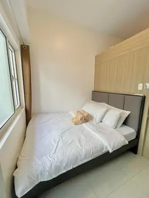a teddy bear laying on a bed in a room at Direct Pool Access in Shore Residences near SM MOA in Manila