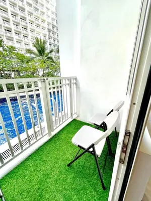 a balcony with green grass and a white railing at Direct Pool Access in Shore Residences near SM MOA in Manila