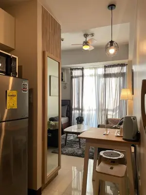 a kitchen and a living room with a table at Cozy Manhattan Araneta Cubao in Manila