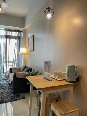 a living room with a table and a couch at Cozy Manhattan Araneta Cubao in Manila