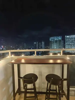 a bar on the roof of a building with two stools at Cozy Manhattan Araneta Cubao in Manila