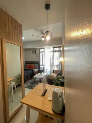 a living room with a table and a couch at Cozy Manhattan Araneta Cubao in Manila