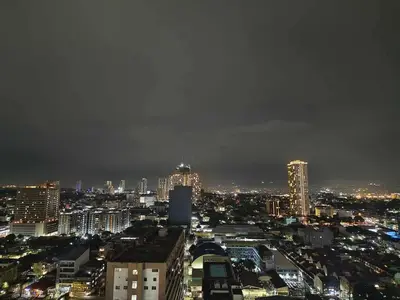 a view of a city at night at Cozy Manhattan Heights 1 Bedroom Araneta Cubao in Manila