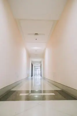 an empty hallway with white walls and a long hall at Cozy Manhattan Heights 1 Bedroom Araneta Cubao in Manila