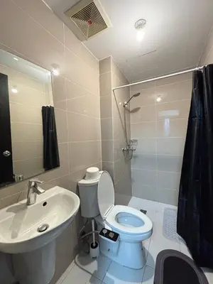 a bathroom with a white toilet and a sink at Cozy Manhattan Heights 1 Bedroom Araneta Cubao in Manila