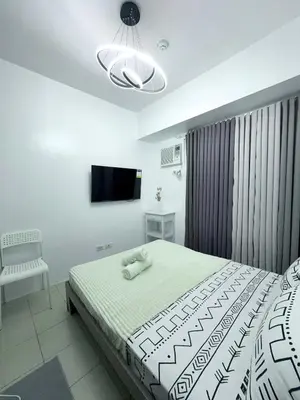 a bedroom with a bed and a television in it at AlRBNB Mandaluyong - by Jam Es in Manila