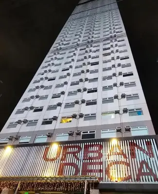 a tall white building with a sign in front of it at AlRBNB Mandaluyong - by Jam Es in Manila