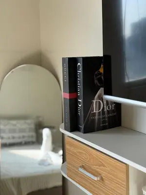 a book sitting on a shelf next to a tv at AlRBNB Mandaluyong - by Jam Es in Manila