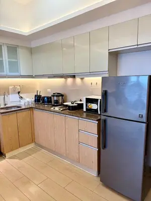 a kitchen with a stainless steel refrigerator and wooden cabinets at Canal View Luxury Stay, Studio type , Massage Chair, Office Desk in Manila