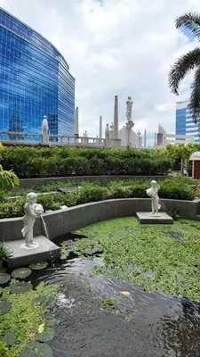 two statues in a pond in front of a building at Canal View Luxury Stay, Studio type , Massage Chair, Office Desk in Manila