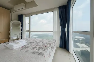 a bedroom with a bed and a large window at SMDC BREEZE Manila Bay Sunset View in Manila