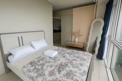a bedroom with a white bed and a table and a chair at SMDC BREEZE Manila Bay Sunset View in Manila