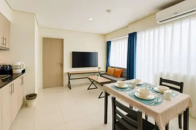 a kitchen and dining room with a table and a television at SMDC BREEZE Manila Bay Sunset View in Manila