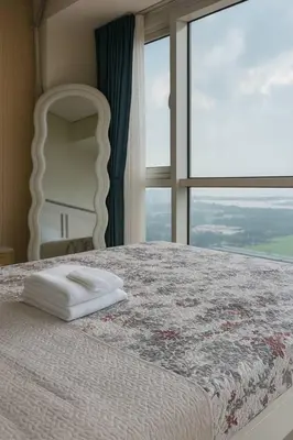 a bedroom with a bed with a large window at SMDC BREEZE Manila Bay Sunset View in Manila