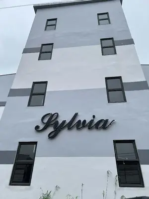 a white building with a sign on it at Cozy Condo for Relaxing Stays & Movie Nights in Imus