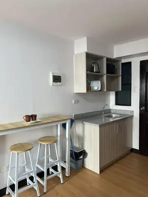 a kitchen with a counter and two bar stools at Cozy Condo for Relaxing Stays & Movie Nights in Imus