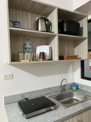 a kitchen counter with a sink and a stove at Cozy Condo for Relaxing Stays & Movie Nights in Imus