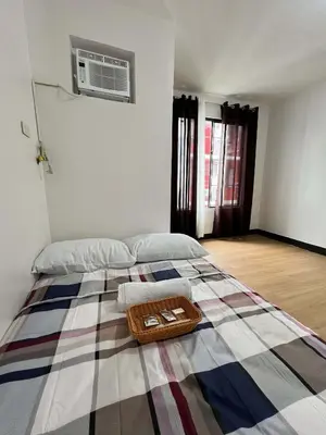 a bedroom with a bed with a basket on it at Cozy Condo for Relaxing Stays & Movie Nights in Imus