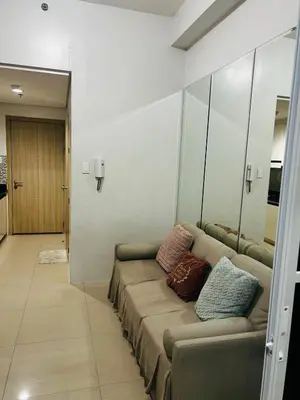 a living room with a couch with pillows on it at Cozy Staycation at Shore Residences near Mall Of Asia MOA in Manila