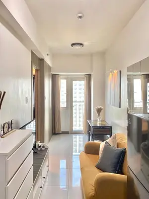 a living room with a couch and a television at 1BR Cozy Minimalist Unit near MOA or Manila Bay in Manila