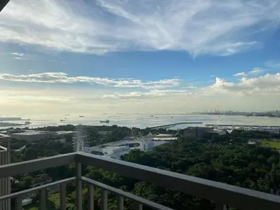 a view from a balcony of a city and a river at 1BR Cozy Minimalist Unit near MOA or Manila Bay in Manila