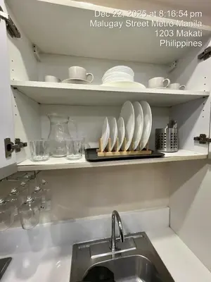 a kitchen with a sink and a shelf with dishes at Spacious Makati Elite Air-2BR - Prime with City View in Manila