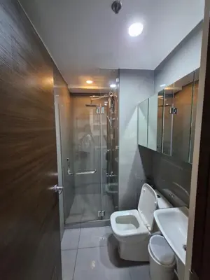 a bathroom with a shower and a toilet and a sink at Spacious Makati Elite Air-2BR - Prime with City View in Manila