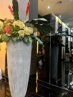 two vases filled with flowers sitting on a floor at Spacious Makati Elite Air-2BR - Prime with City View in Manila
