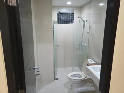 a bathroom with a shower and a toilet and a sink at GambinoAirbnb in Manila