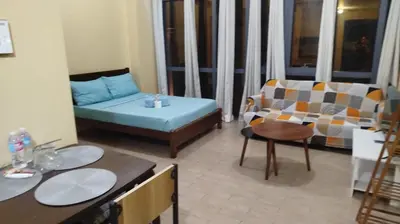 a small living room with a couch and a chair at GambinoAirbnb in Manila