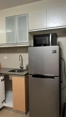 a kitchen with a microwave on top of a refrigerator at GambinoAirbnb in Manila