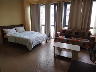 a bedroom with a bed and a couch and a chair at GambinoAirbnb in Manila