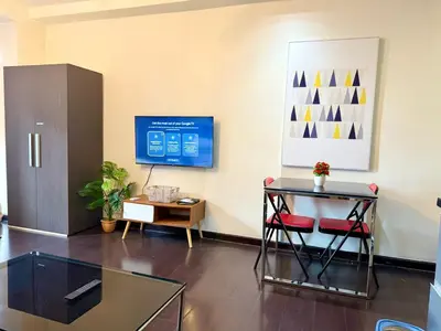 an office with a glass table and a desk and a tv at The Gramercy Residences Executive 1 bedroom with Balcony in Manila