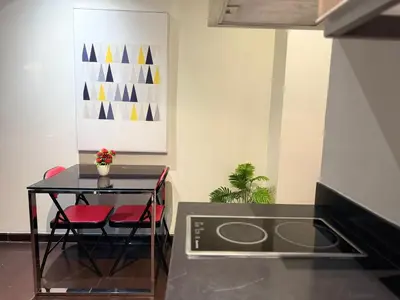 a kitchen with a table and two red chairs at The Gramercy Residences Executive 1 bedroom with Balcony in Manila