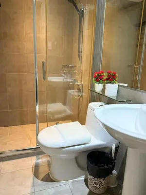 a bathroom with a toilet and a shower and a sink at The Gramercy Residences Executive 1 bedroom with Balcony in Manila