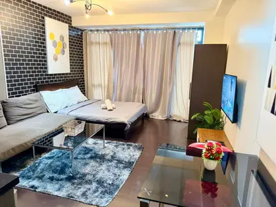 a living room with a couch and a table at The Gramercy Residences Executive 1 bedroom with Balcony in Manila