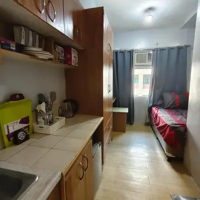 a kitchen with a sink and a bed in a room at Fully Furnished Condo at Cyberzone-Filinvest in Manila