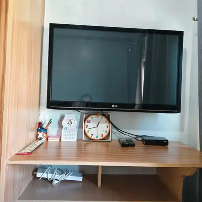 a flat screen tv sitting on top of a wooden shelf at Fully Furnished Condo at Cyberzone-Filinvest in Manila